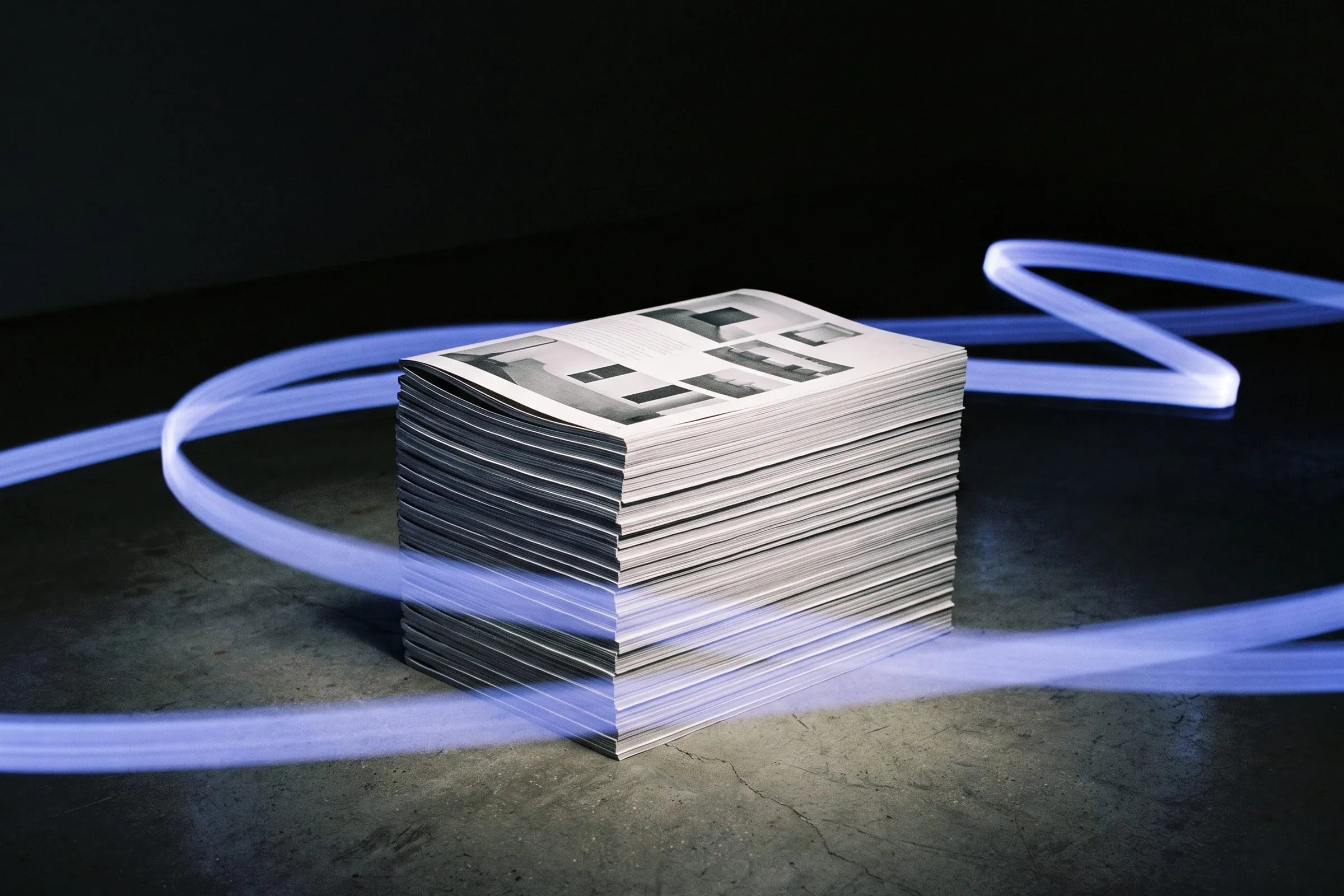 A tall stack of identical printed pages with light streaking past it.