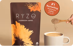 Hand sprinkling Ryze Mushroom Coffee into a white cup filled with coffee next to a Ryze Mushroom Coffee package.